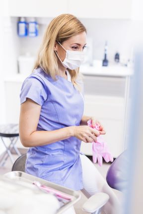 guantes que llevan del dentista de sexo femenino en clinica